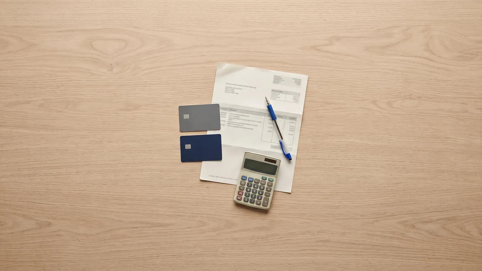 Credit cards and a calculator beside a statement.
